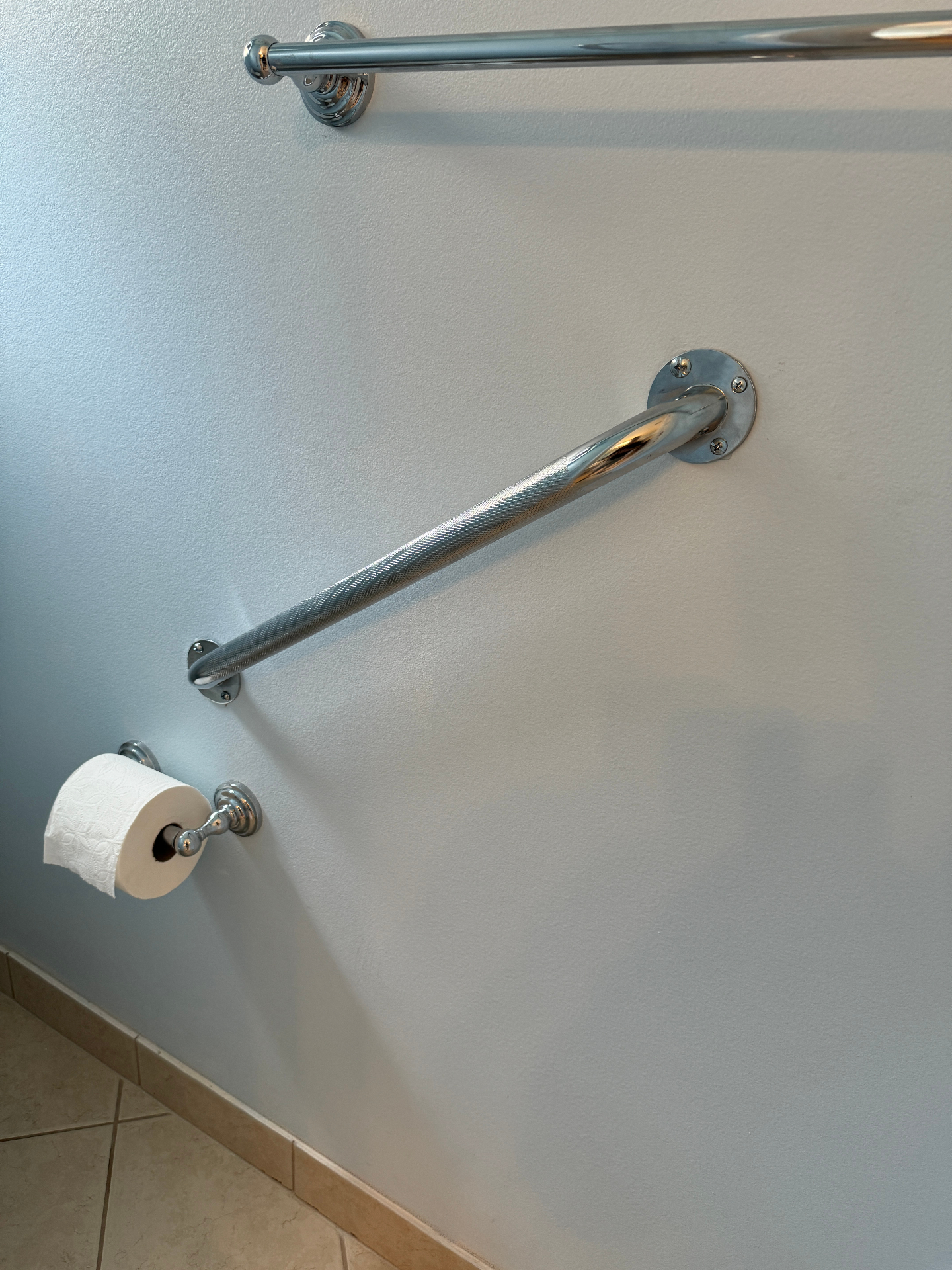 Knurled chrome grab bar near toilet for support